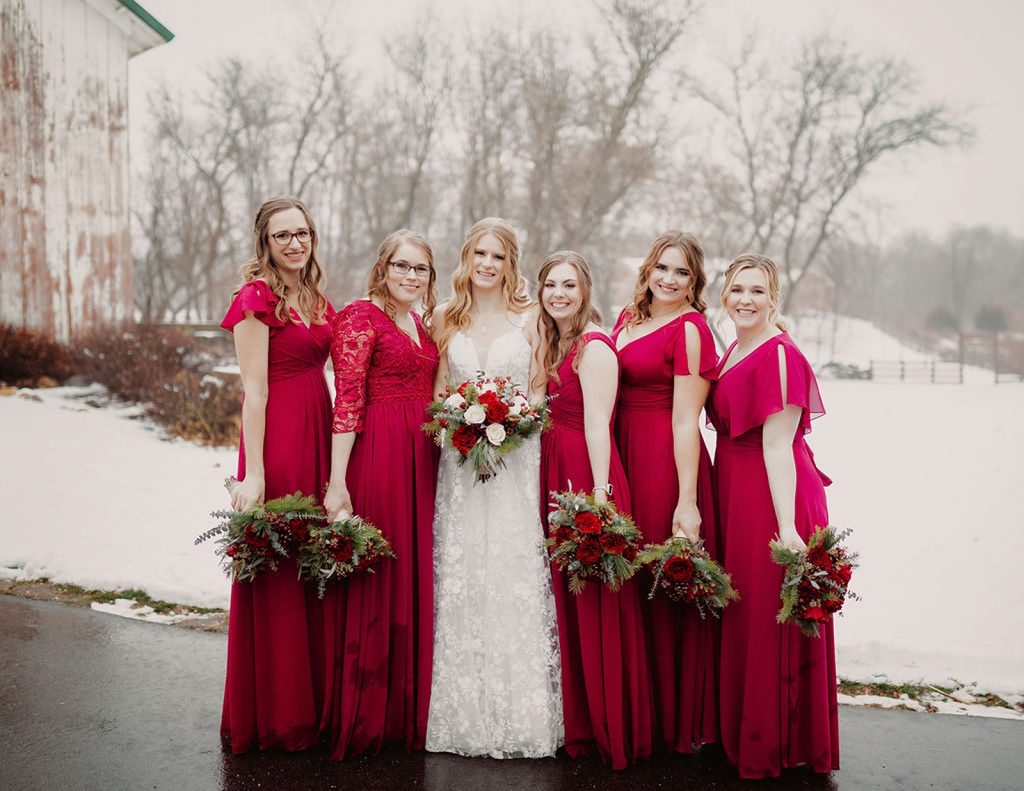 Wisconsin winter wedding party bridesmaids and bride smiling near snow