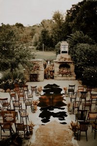 Intimate boho western wedding ceremony with cowhides down the aisle