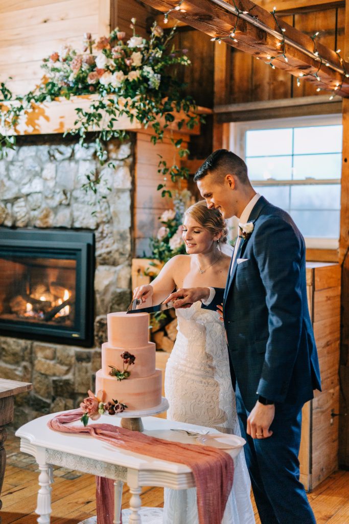 Bride and groom cut their wedding cake on their wedding day at a barn wedding venue in Wisconsin